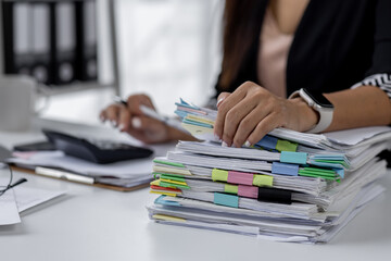 Wall Mural - Businesswoman hands working in Stacks of paper files for searching and checking unfinished document achieves on folders papers at busy work desk office
