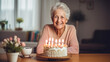 A cheerful senior woman celebrates her 80th birthday alone at home with a festive cake and candles. ai generative