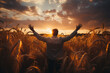 Successful businessman standing with arms raised in wheat field at sunset