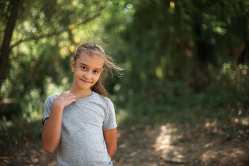 portrait of a cute caucasian girl in the forest on a warm autumn day. hair fluttering in the wind