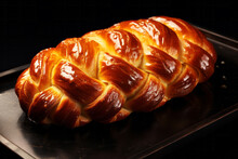 Sweet traditional braided bread with crispy brown crust on dark background. Homemade bakery concept