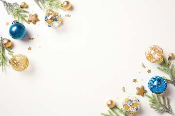 Wall Mural - Christmas frame of fir branches with gold and blue ornaments on white table. Flat lay, top view, copy space.