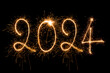 Happy New Year 2024. Sparkling burning text Happy New Year 2024 isolated on black background.