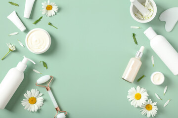 Wall Mural - flat lay composition with natural beauty products and chamomile buds on green background.