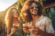 Young people celebrating summertime party holding vine glasses outside. Happy friends have fun on the beach. Summer vacations, lifestyle beverage concept.