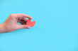 female hand hold paper model of healthy thyroid on light blue background