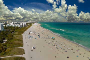 Canvas Print - South Beach sandy surface with tourists relaxing on hot Florida sun. Tourism infrastructure in southern USA. Miami Beach city with high luxury hotels and condos