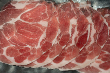 Wall Mural - Rare sliced raw beef with marbled texture served on black plate.