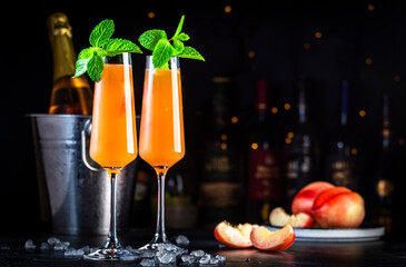 Wall Mural - Peach Bellini classic cocktail drink with sparkling wine and peach puree, syrup and ice, dark bar counter background