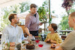 © Halfpoint - Waiter bringing food to the table in the restaurant.