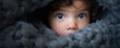 Cute baby looking out from under blanket
