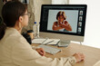 Focus on screen of computer with shots of young female fashion model sitting in isolation and looking at camera during photo session