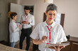 © Miljan Živković - one woman female entrepreneur team leader stand in front of her colleagues in hotel room prepare for business conference meeting real people entrepreneurs copy space