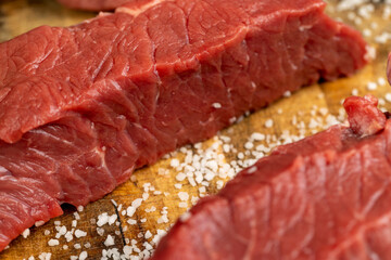 Wall Mural - sliced piece of fresh raw beef during salting