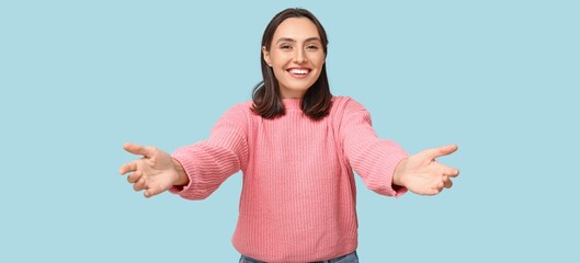 Wall Mural - Beautiful young woman opening arms for hug on light blue background