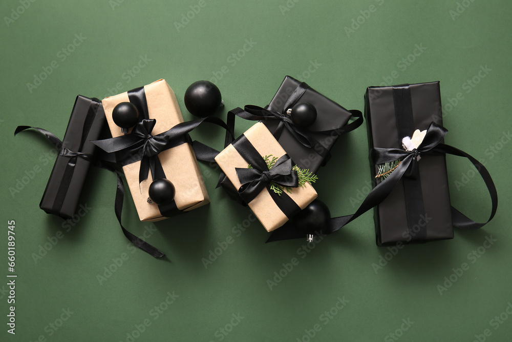 Many gift boxes with coniferous branch and Christmas balls on green background