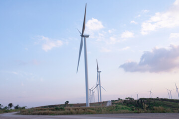 Wall Mural - windmill turbine farm for electricity generation on landscape mountain at sunset sky, green power in