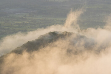  Morning foggy landscape. Fog and low clouds over the hills. Top view of clouds at sunrise. Beautiful aerial photo. Natural background.