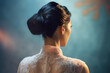 Back view of woman with black hair in elegant wedding updo hairstyle. 