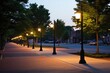 sidewalk lined with street lamps illuminating at dusk