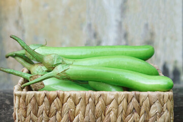 Wall Mural - Fresh green long eggplants in basket. Concept, agriculture crop in Thailand. Food ingredient which can be cooked for variety delicious menu. Healthy eating, high fiber, reduce cholesterol levels.