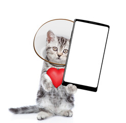 Poster - Cute tabby kitten with protective cone collar on her neck  holds red heart and shows big smartphone with empty screen. Isolated on white background