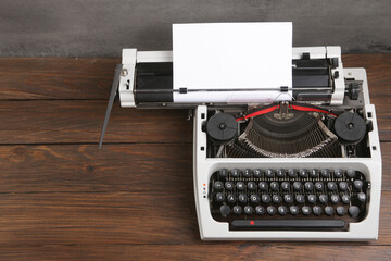 Fototapete - vintage typewriter on the table with blank paper on wooden desk - concept for writing, journalism, blogging