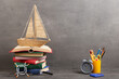 Education is a journey concept, toy boat and books on the table, inspiration for a writing a fairy tale. Elementary school supplies