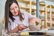 Woman creating a bowl with clay in pottery class. Crafts concept 