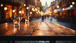Empty wooden table with candles in the evening with blurred background of atmospheric city street decorated with cozy lights