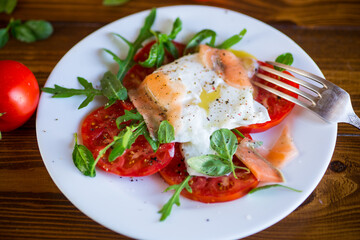 Wall Mural - Cooked poached egg with herbs, lightly salted salmon and tomatoes with spices .