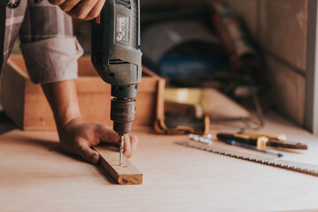 close-up hand a Young man Carpenter works on woodworking machinery in a carpentry shop. The workshop looks professional, highly skilled, and the craftsmen are true craftsmen.