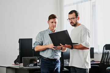 Wall Mural - Portrait of two professional male programmers working on computer in diverse offices. Modern IT technologies, development of artificial intelligence, programs, applications and video games concept