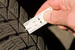 close-up of measuring tread depth of car tire