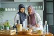 © maya1313 - Cute Girl And Her Muslim Mom In Hijab Preparing Pastry For Cookies In Kitchen, Baking Together At Home. Islamic Lady With Daughter Enjoying Doing Homemade Pastry, Free Space