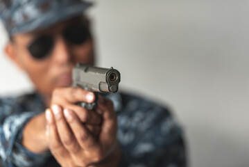 Police cop constable holding Pistol Is preparing to shoot bandit culprit in abandon building. Cop hunter killer use black glasses preparing with short handgun.