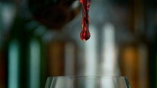 Super Slow Motion Shot Of Camera Following Red Wine Stream From Bottle Into Glass At 1000fps.