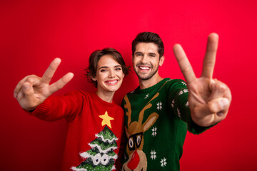 Sticker - Photo of pretty charming married couple wear ornament sweaters showing two v-signs isolated red color background