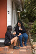 © Austockphoto - Aboriginal mother and daughter drinking from mugs on back porch