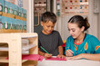 © Austockphoto - Young boy writing with educator