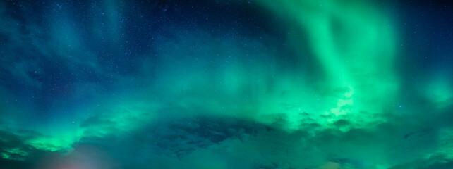 Wall Mural - bright and active aurora borealis or northern lights glowing in the night sky on arctic circle