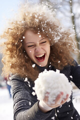 Snowball fight. Young women throwing snowball in focus, motion blur