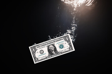 Global financiall crisis concept. Dramatic image of US Dollar sinking in water. Close up money sinking in water as symbol of global economic and financial crisis and recession.