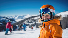 Portrait of a kid skier in helmet and winter clothes on the background of snow-covered mountain slope