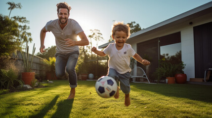 Joyful father and son play with a soccer ball in the front yard of the house