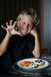 an eight-year-old boy is preparing for Halloween, the boy is painting gingerbread cookies, handmade, decorated place