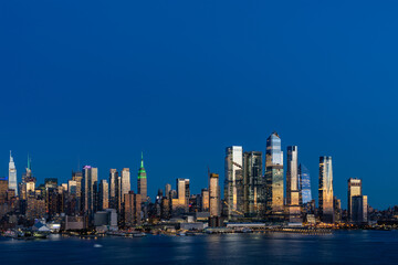 Wall Mural - Aerial New York City skyline from New Jersey over the Hudson River with the skyscrapers of the Hudson Yards district at night. Manhattan, Midtown, NYC, USA. A vibrant business neighborhood