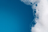 Fototapeta  - Detergent foam bubble on water. Blue background, Soap sud