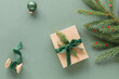 © RooM The Agency - Overhead view of a Christmas arrangement with a wrapped gift box, fir branches, berries, a Christmas bauble and a spool with green velvet ribbon