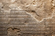 Damaged ancient cuneiform carved on stone wall or rock, fiction view
